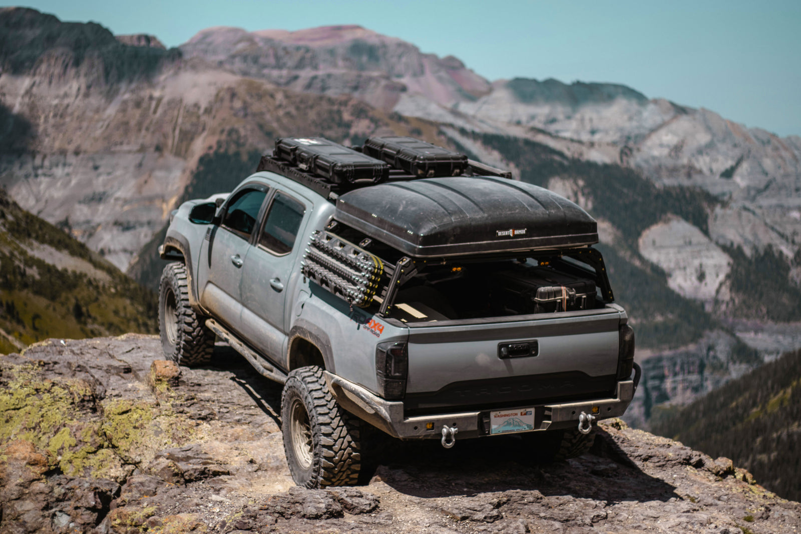 Xtrusion Overland bed rack with traction boards and hard shell roof top tent on a Toyota Tacoma in the Rocky Mountains.