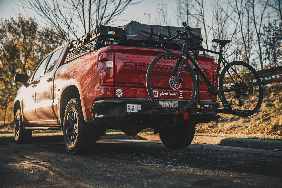 Rear view of a Silverado 1500 with XBRS bed bars, rooftop tent and hitch bike rack