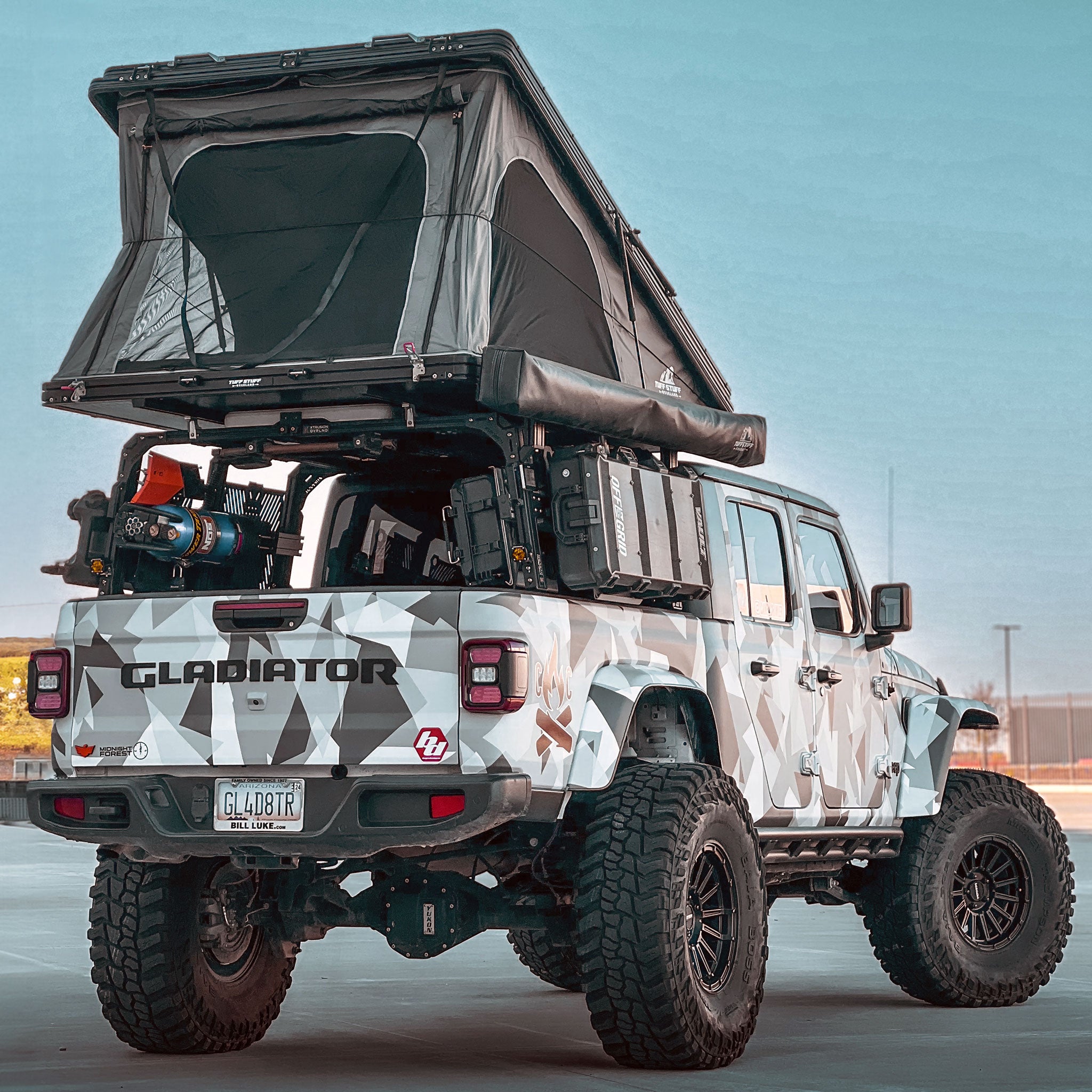 Built Jeep Gladiator with 9 Degree XTR3 - 22 inch high bed rack, open roof top tent, awning, storage cases, shovel, Power Tank, and off-road gear.