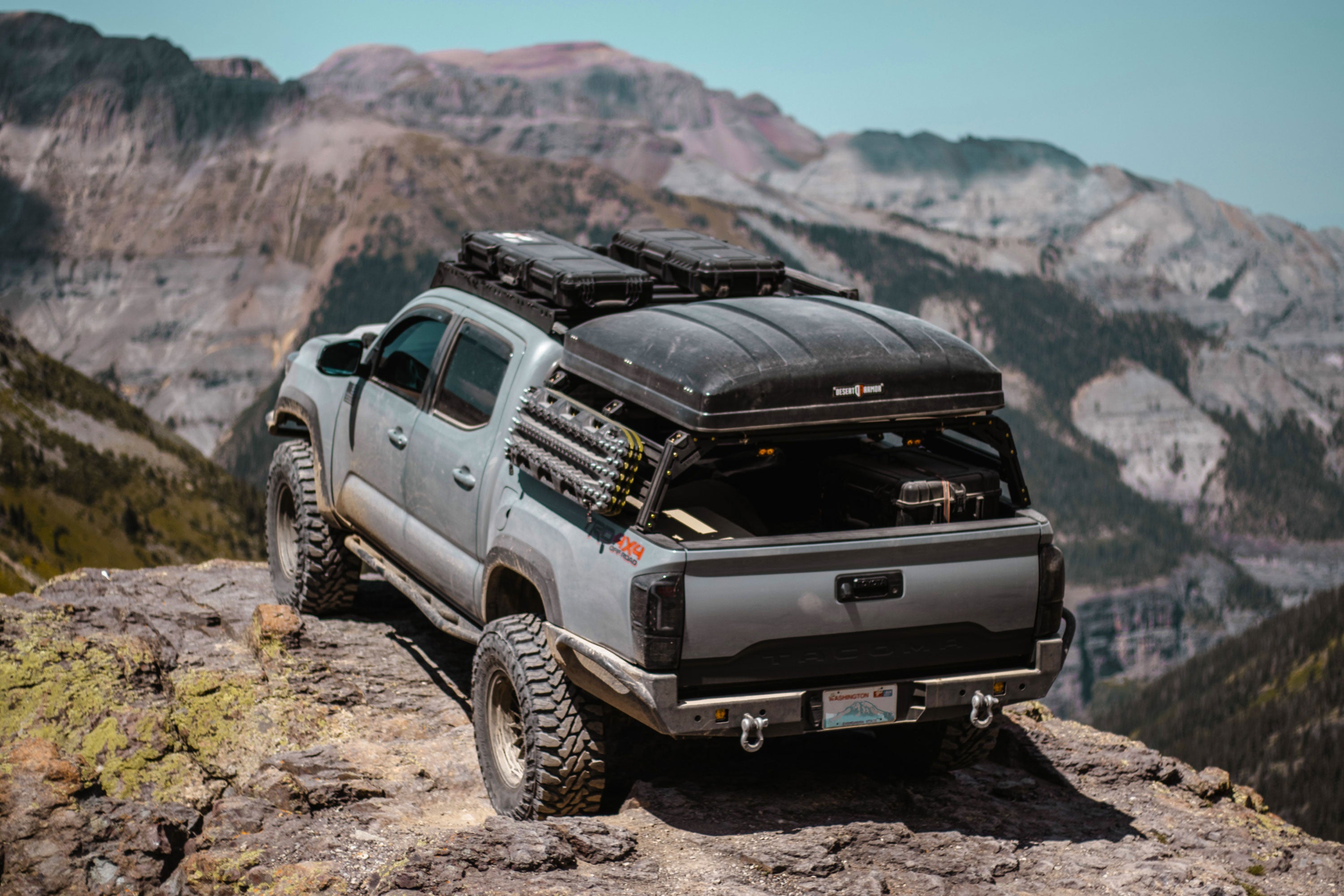 Xtrusion Overland bed rack with traction boards and hard shell roof top tent on a Toyota Tacoma in the Rocky Mountains. 