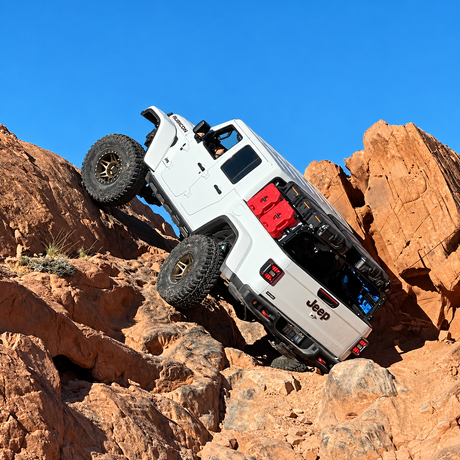 White Jeep Gladiator with XTR bed rack and Rotopax packs climbing red sandstone