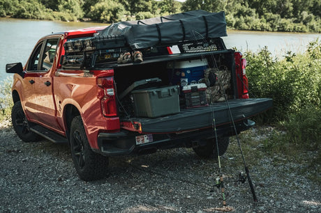 Silverado 1500 with a rooftop tent on XBRS bed bars, tailgate open with camping gear