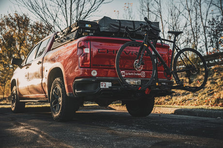 Rear view of a Silverado 1500 with XBRS bed bars, rooftop tent and hitch bike rack