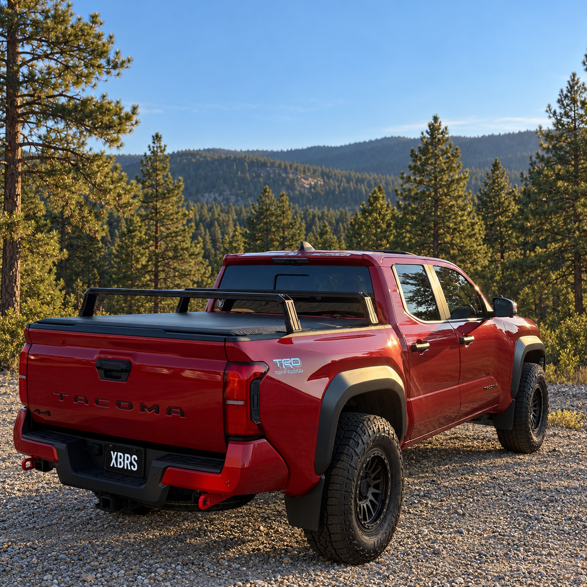 XBRS bed bars over a soft tonneau cover on a red 2024+ Toyota Tacoma, rear three-quarter view
