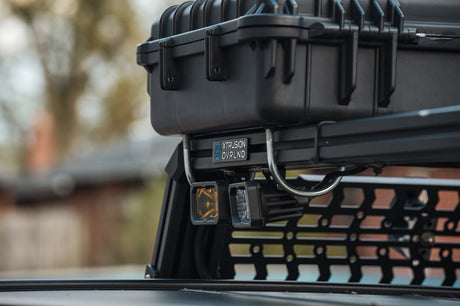 Close-up of an XBRS corner bracket with Xtrusion Overland badge and pod lights on a Silverado