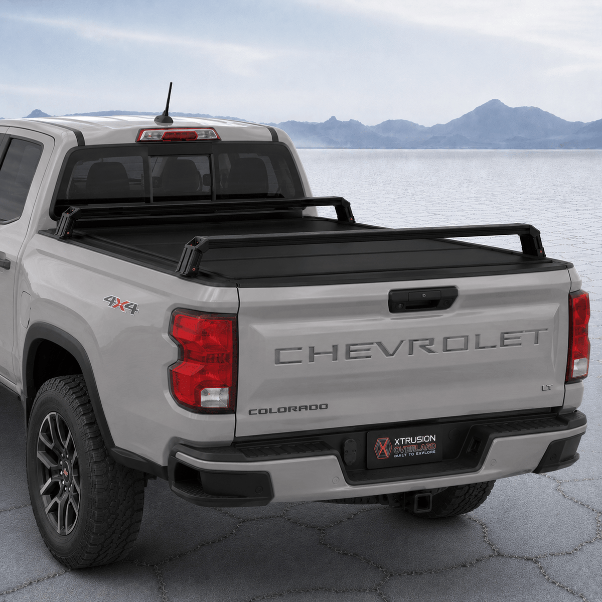 XBRS bed bars over a hard folding tonneau cover on a silver 2023+ Chevy Colorado, rear three-quarter view