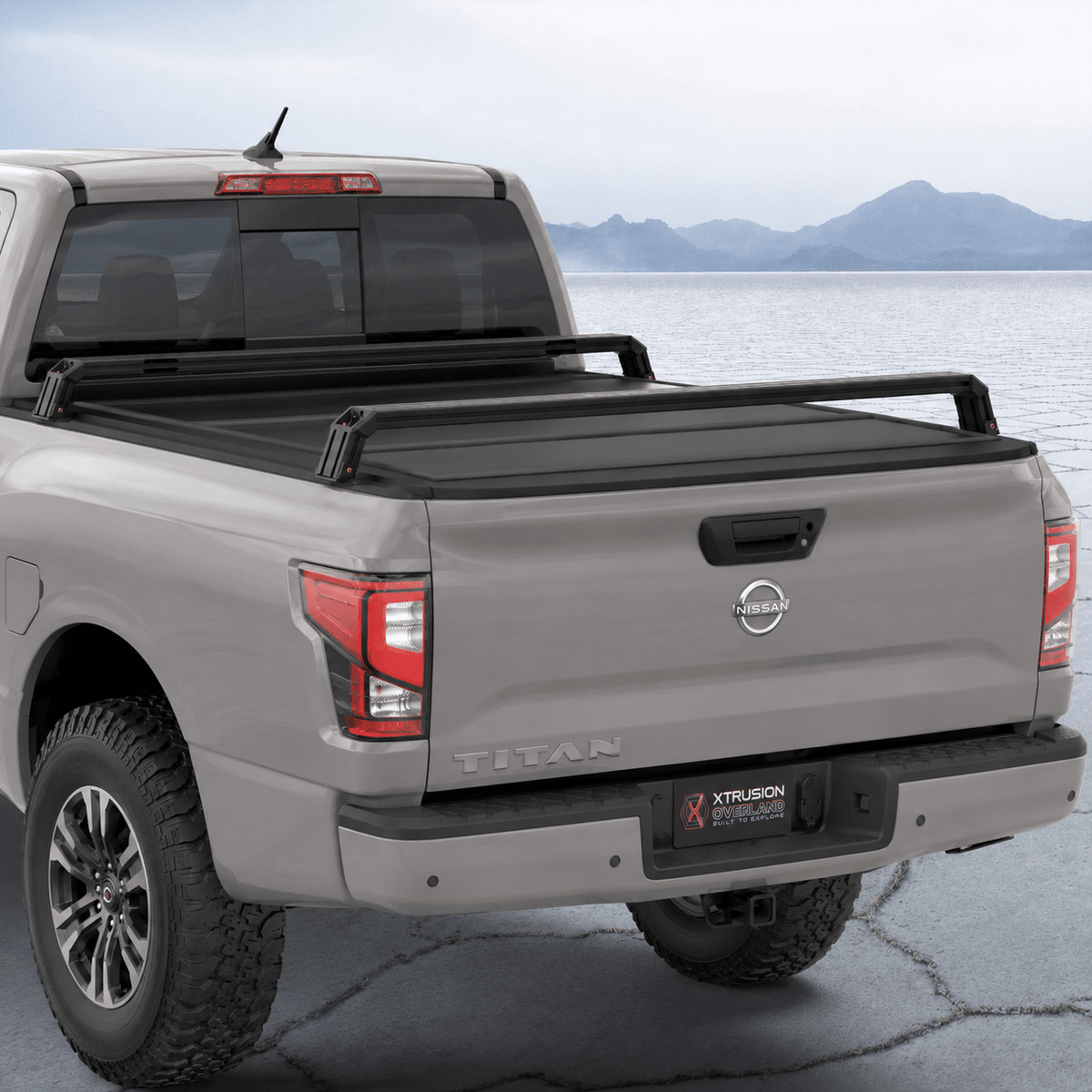 XBRS bed bars over a hard tonneau cover on a silver Nissan Titan, rear three-quarter view