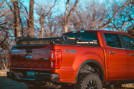 Red Ford Ranger FX4 with XBRS bed bars and a Tread MOLLE Plate on each side, axe and shovel strapped on